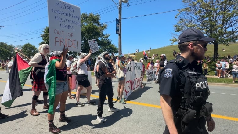 Group of protestors stand in the middle of the road. 