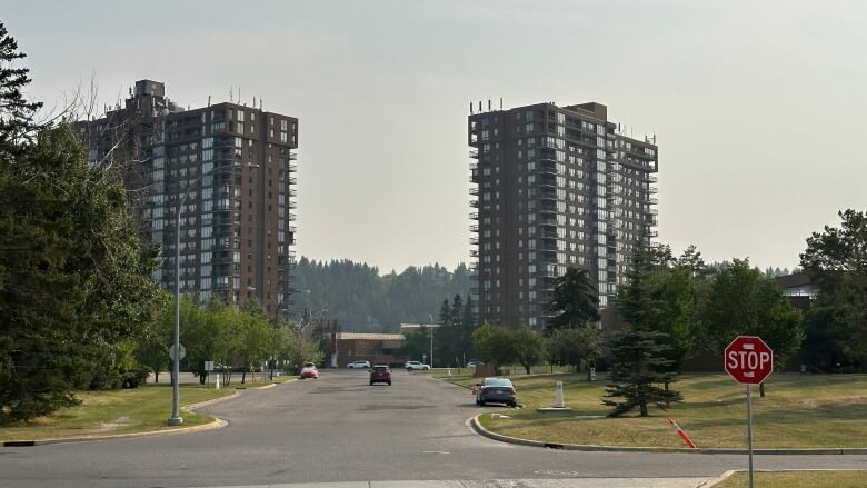 Hazy skies over two brown apartment buildings.