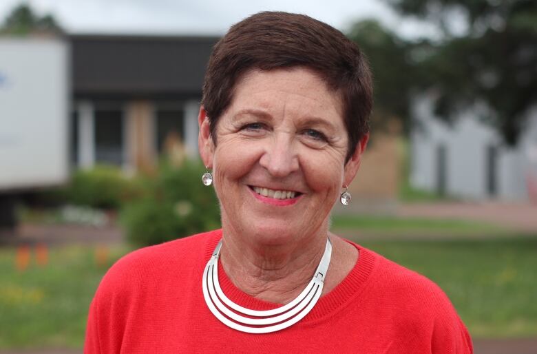 woman wearing red shirt smiles at camera