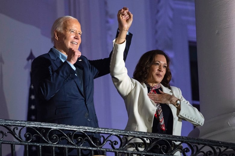 President Joe Biden raises the hand of Vice President Kamala Harris after viewing the Independence Day fireworks display over the National Mall from the balcony of the White House, Thursday, July 4, 2024, in Washington. 