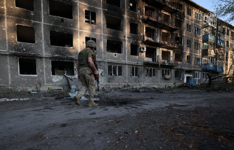 A Ukrainian soldier walks past a destroyed building Chasiv Yar, in Ukraine's Donetsk region, during a patrol on Wednesday, July 24, 2024.