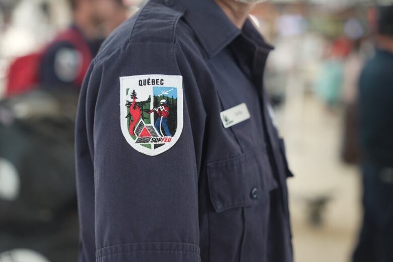 A close up of the SOPFEU logo on a patch sewed onto the sleeve of a firefighter uniform. 