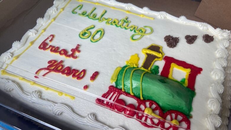 A cake with a train on it says 'celebrating 60 great years.'