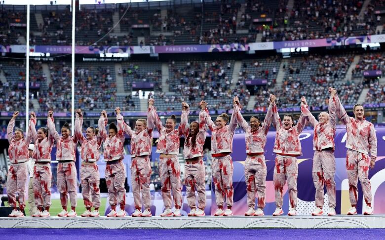 Silver medalists of Team Canada celebrate on the podium during the Women's Rugby Sevens medal ceremony