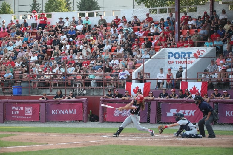 A baseball player swings at the plate.