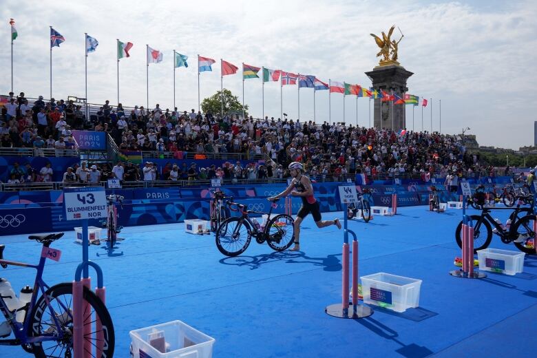 A triathlete runs to his bike.