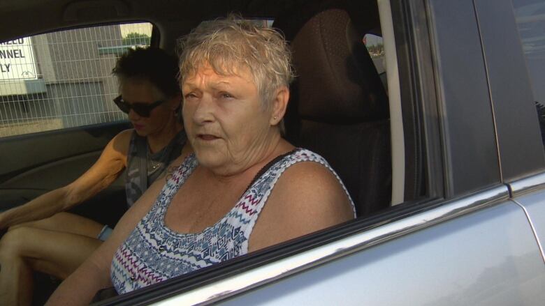 A woman sits in a car. 