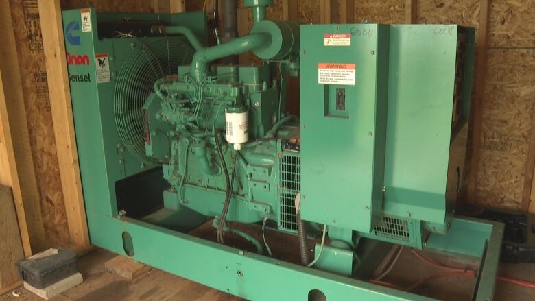 A large green piece of metal equipment with various parts.