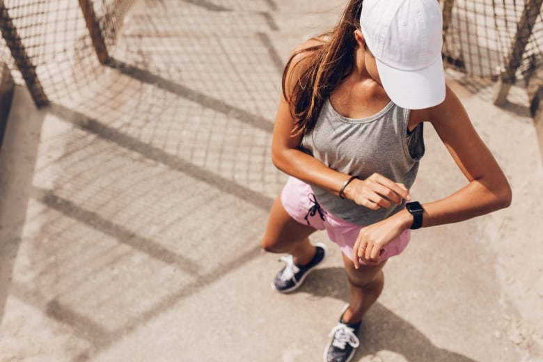 Female runner looking at smart watch heart rate monitor.