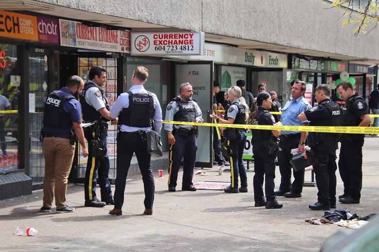 Many police officers stand outside a currency exchange