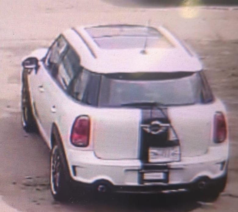 A white Mini Cooper with black stripes. 