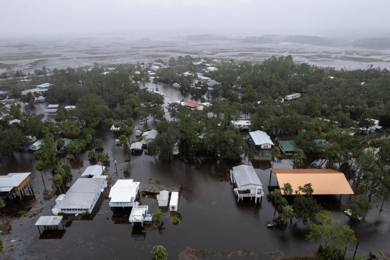 An aerial view shows houses and streets flooded.