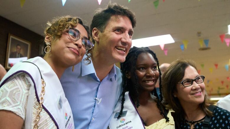 A group of four people smile and pose for a photo at a celebration. 