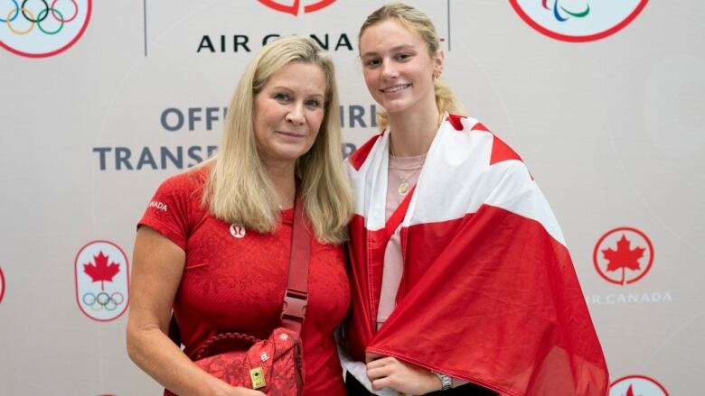 Summer McIntosh and her mother pose for a photo with the Canadian flag