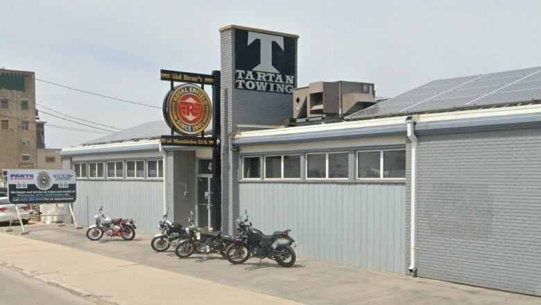 Exterior of a grey-painted building with motorcycles parked in front.