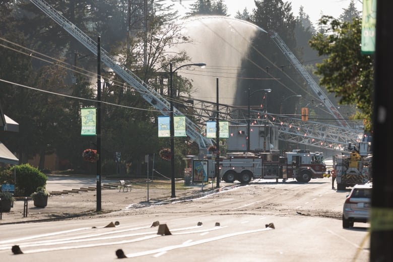 Fire truck and crew members can be seen spraying jets of water at a city neighbourhood.