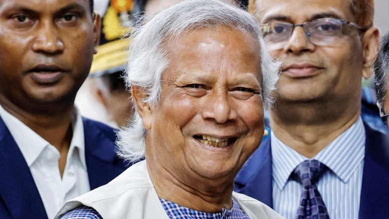 An elderly man smiles widely.