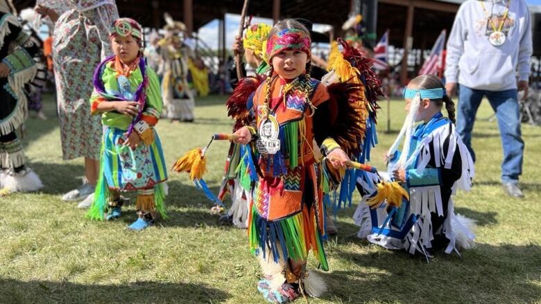 Little kids wearing their powwow regalia at a powwow