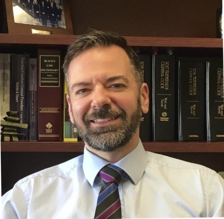 Man with beard wearing a dress shirt and tie.