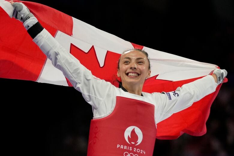 A person celebrates by holding a flag. 