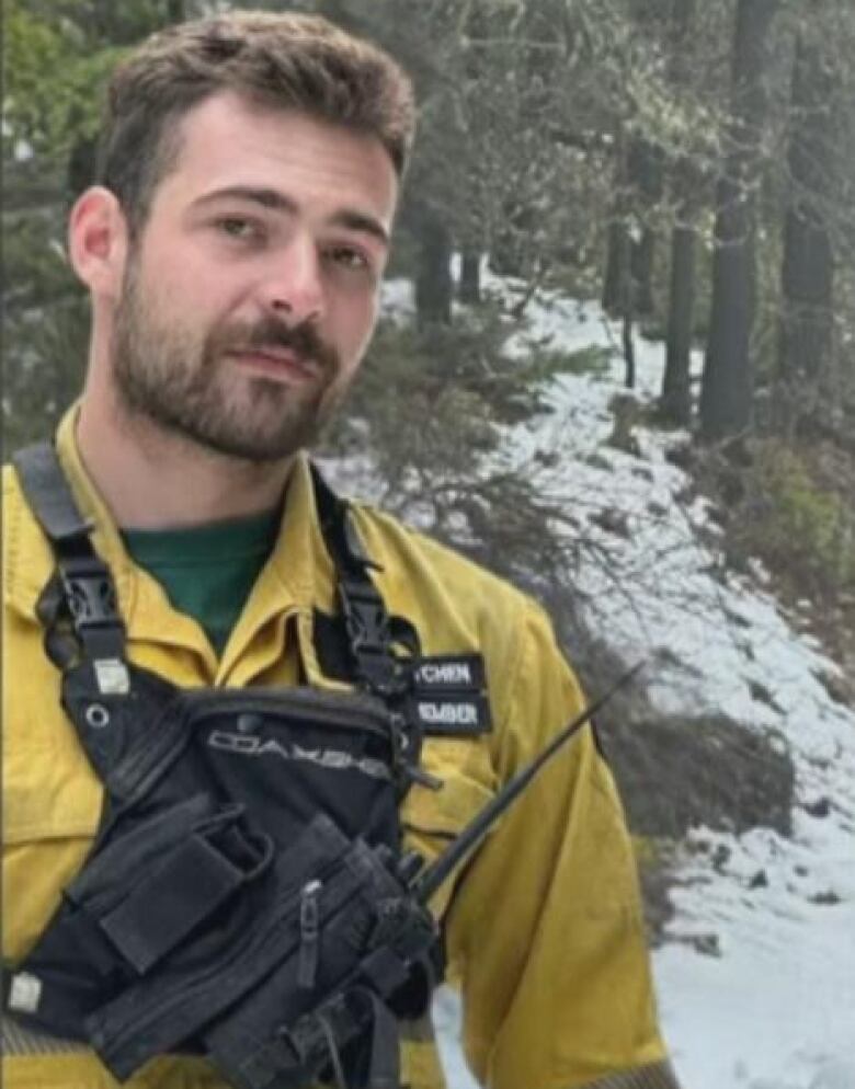 A bearded man wearing yellow firefighting gear looks toward the camera.