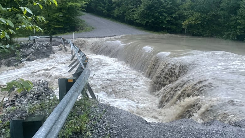 Water floods a rural road. 