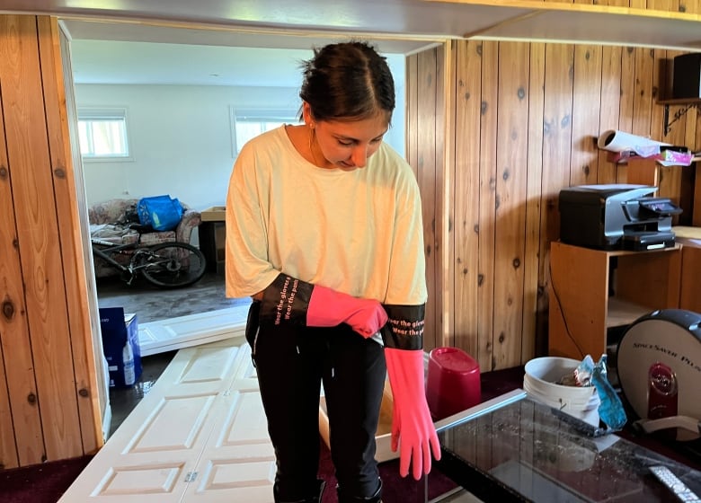 A woman pulls up cleaning gloves