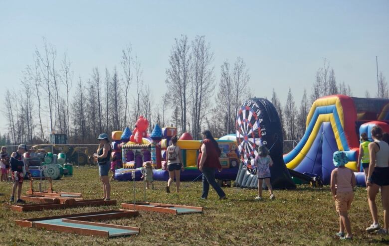 Bouncy castles with kids walking to them 