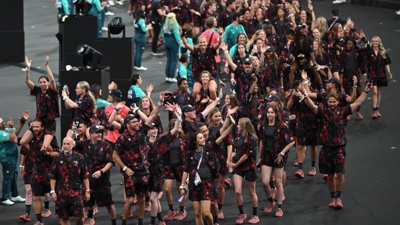 Athletes in a group are parading together.