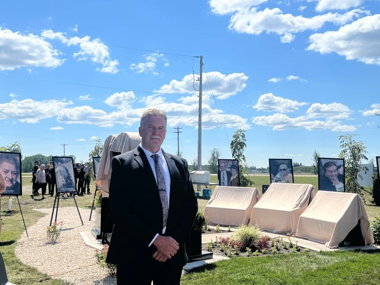 A man stands in front of a monument. 