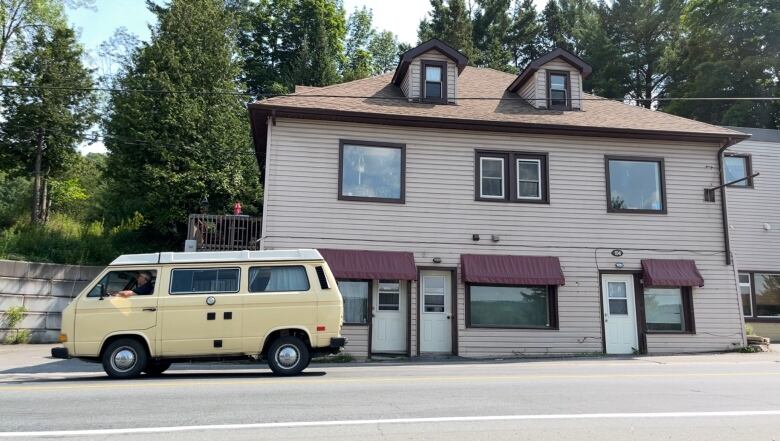 A yellow van passes by an eightplex apartment building in Haliburton County.