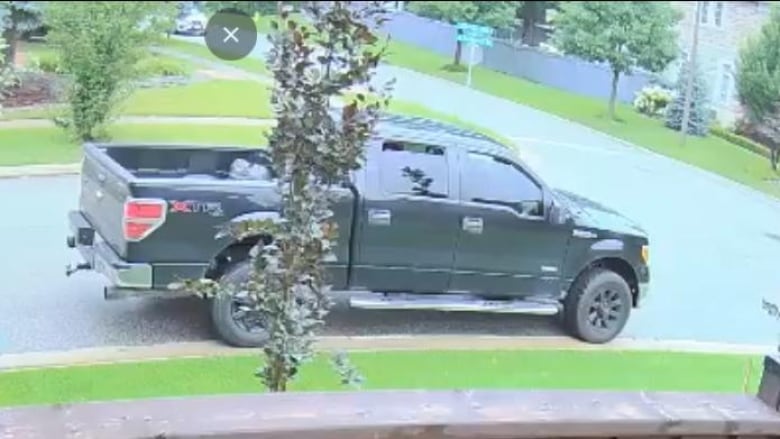 A black pickup truck is seen outside of a home.