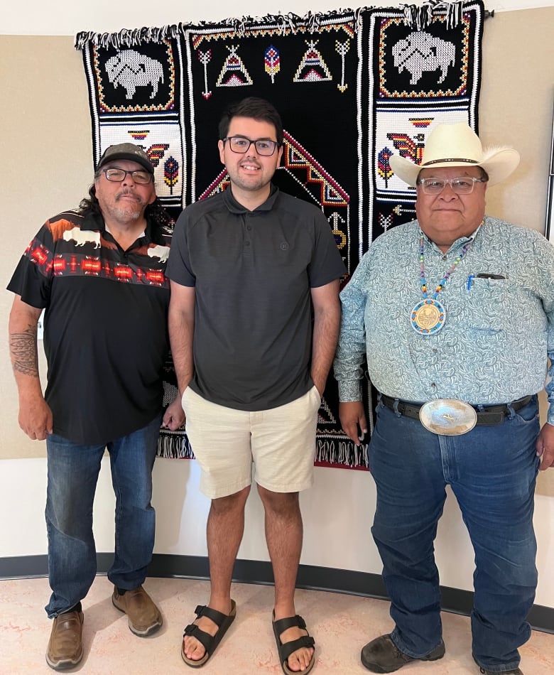 Three men standing together for a photo. 