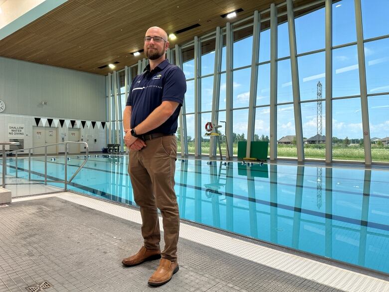 A man in a large indoor pool facility.