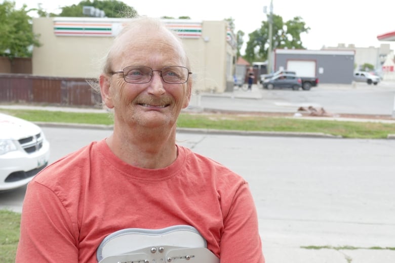 A man is standing in front of a 7-Eleven store.