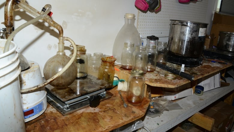 Drug paraphernalia, including beakers, boilers and various liquids, are seen on a table.