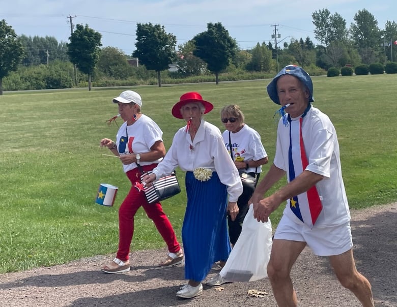 four people walk in an Acadian tintamarre outside