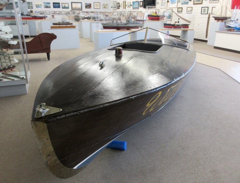 An 18-foot vintage speedboat, made of a dark mahogany wood.