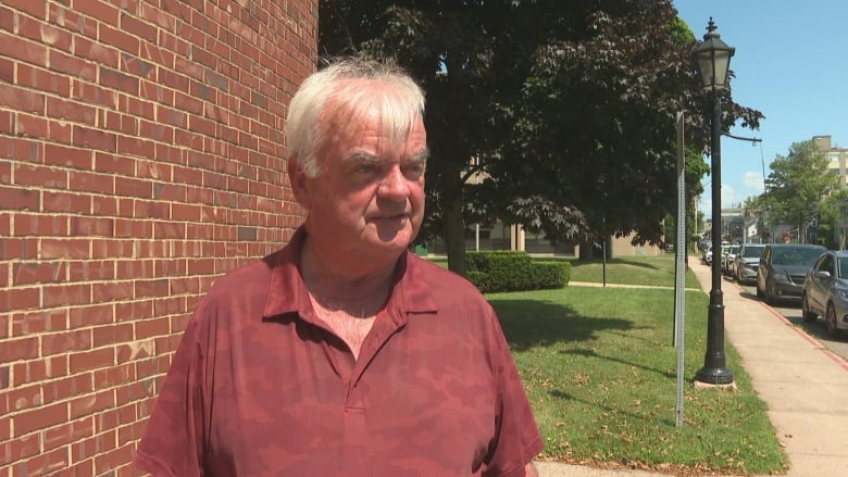 Man in red shirt looks off camera