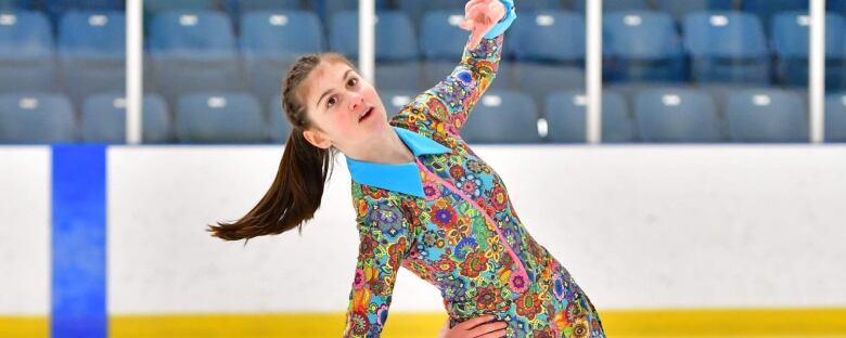 Breanna Williams, a 15 year old figure skater from Windsor, is in the middle of a performance, wearing a colourful costume.