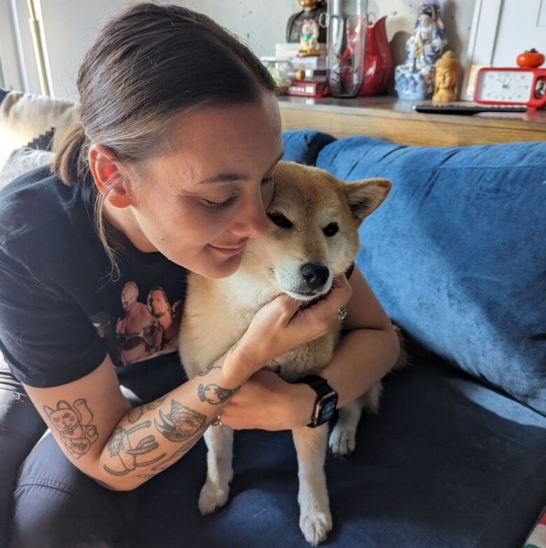 Close-up of Sandra Wong hugging one of her Shibas. 