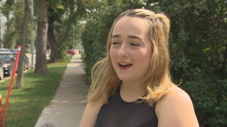 A girl talks to a reporter in front of the camera