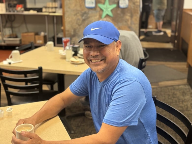 A man in a blue T-shirt and blue cap.