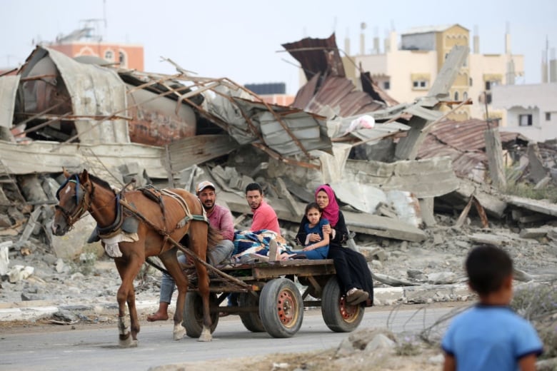 A Palestinian family rides in the back of a horse-drawn carriage.