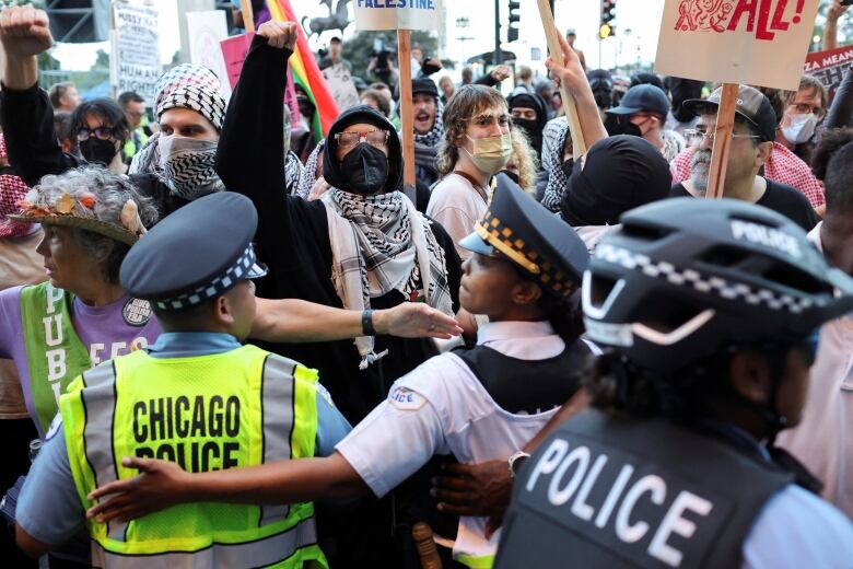 Police officers keep a crowd of protesters at bay. 