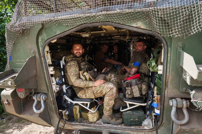 Ukrainian servicemen sit inside their APC after returning from the Russian Kursk region, near the Russian-Ukrainian border, Sumy region, Ukraine, on Wednesday, Aug. 14, 2024.