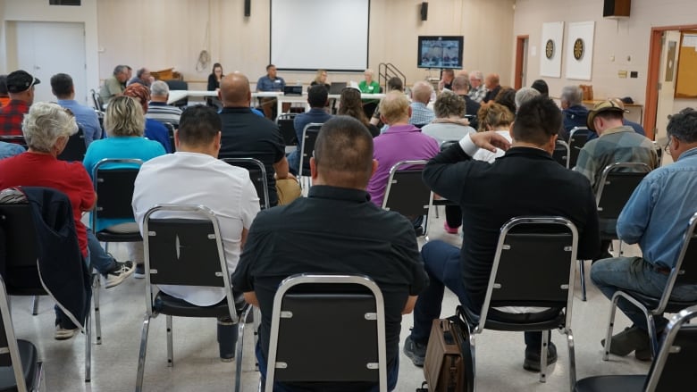 People sitting on chairs in a room.