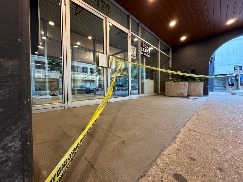 Yellow caution tape is tied across the doorway of an apartment. 