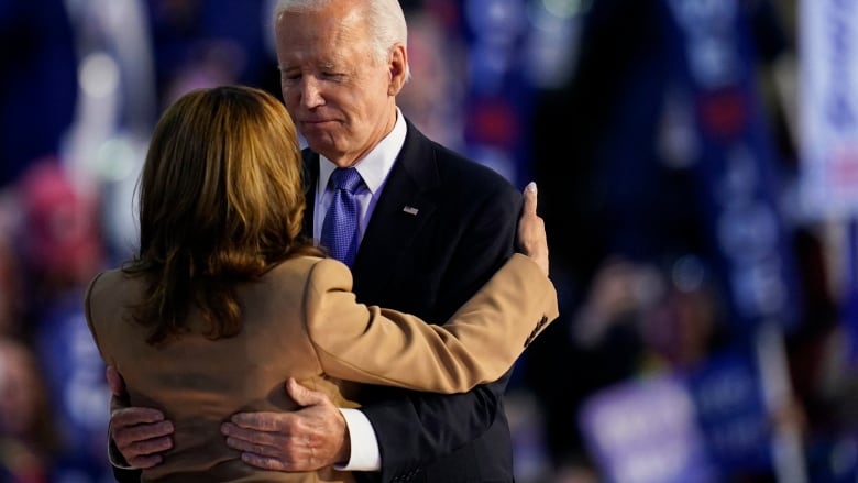 Biden gazes at Harris as he hugs her