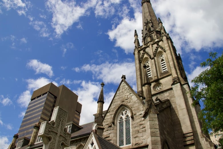 A stone church seen from a low angle against a backdrop of blue sky.